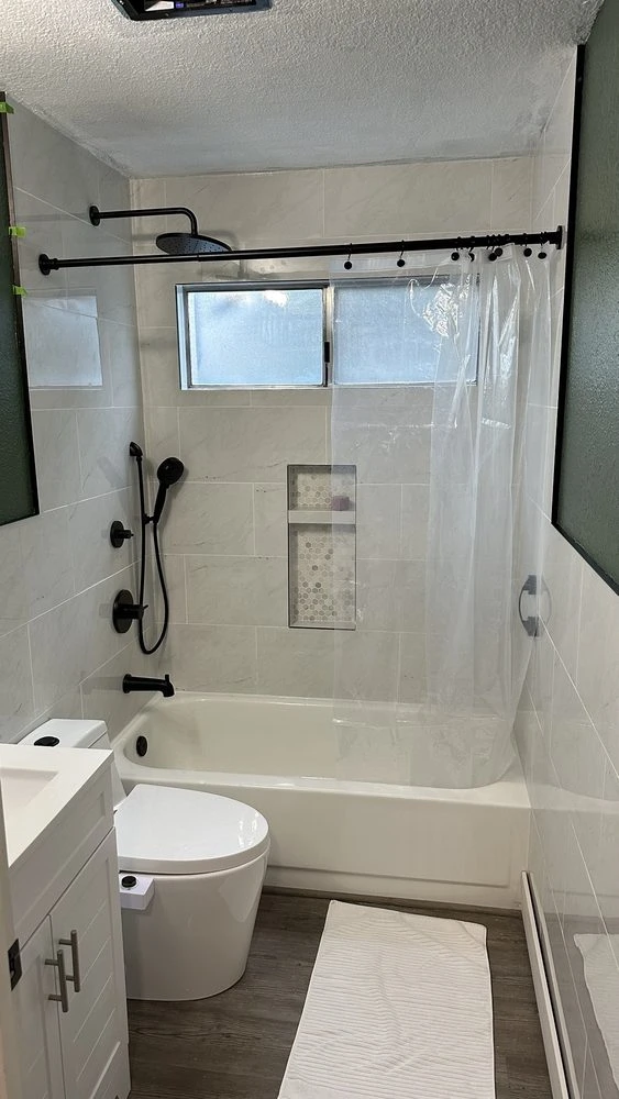 Large-format floor tile and glass shower enclosure with freestanding tub in a Golden master bathroom