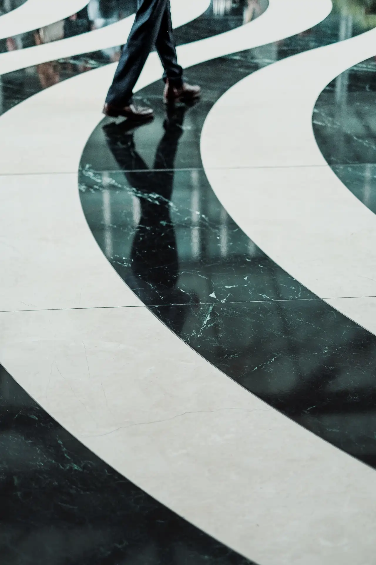 Dramatic black and white marble spiral floor pattern in a commercial lobby