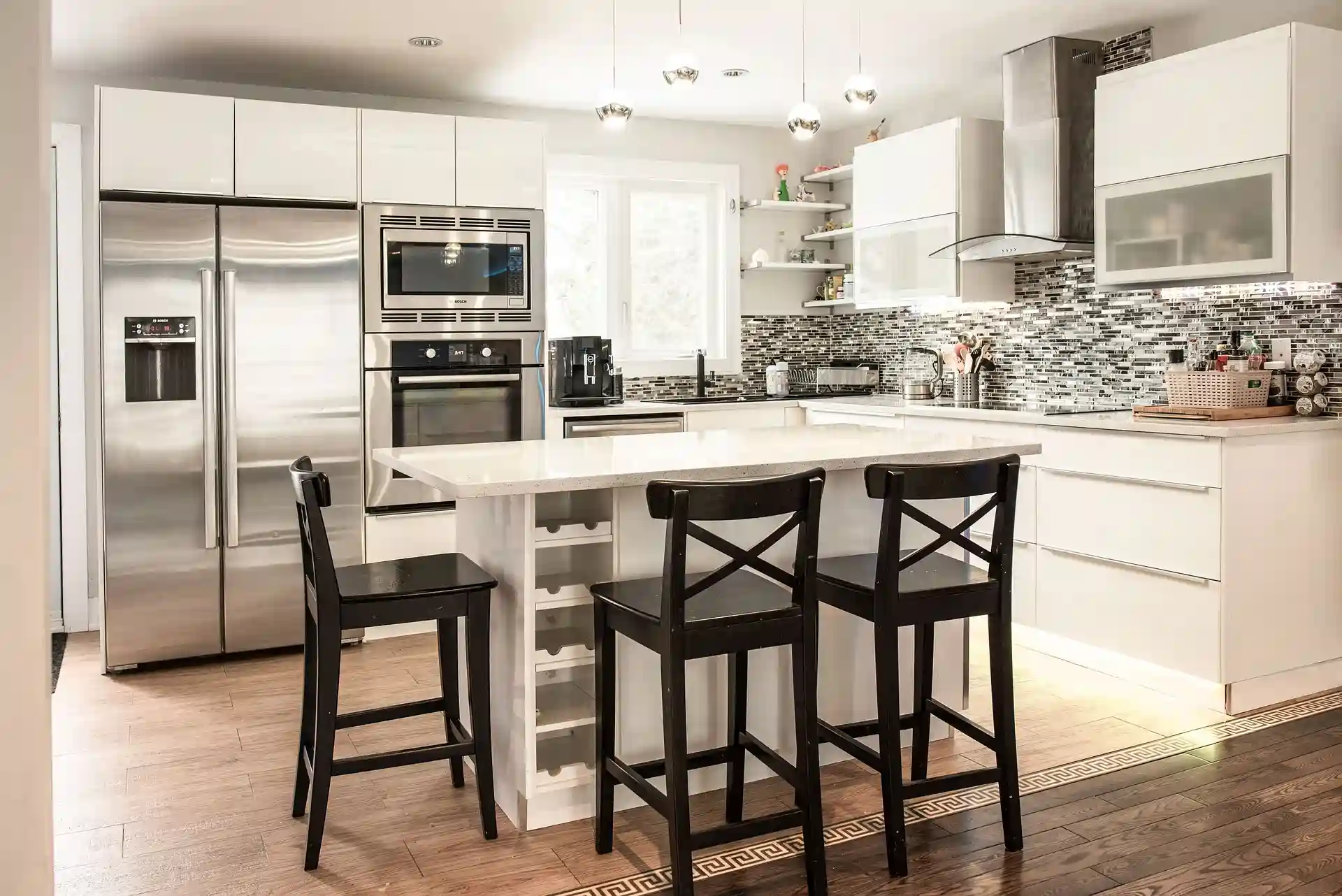 White subway tile kitchen backsplash with mosaic glass accent strip and stainless appliances